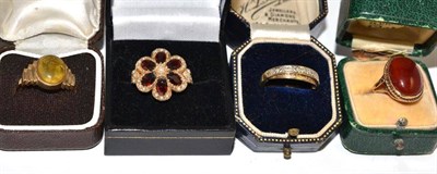 Lot 181 - A garnet set 9ct gold ring, two 9ct gold rings and a cornelian set ring stamped '9CT' (4)