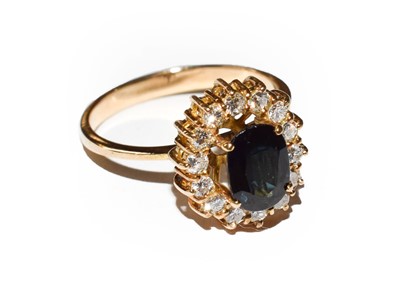 Lot 125 - A sapphire and diamond cluster ring, the oval...