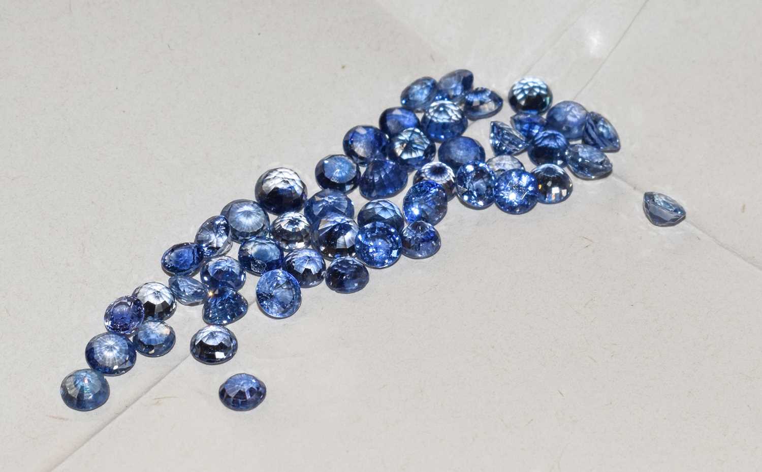 Lot 139 - A quantity of loose round cut sapphires,...
