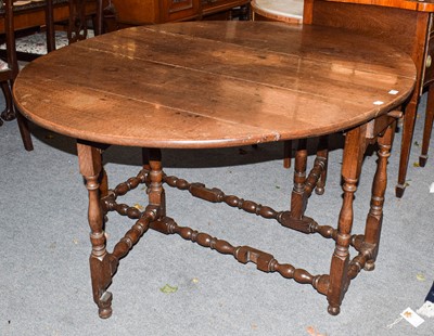 Lot 522 - A Georgian oak gateleg dining table