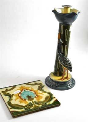 Lot 416 - An Art Nouveau earthenware candlestick modelled with a crane at its base and a Mintons tile