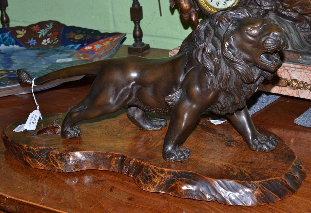 Lot 442 - A Japanese bronze lion with wood stand