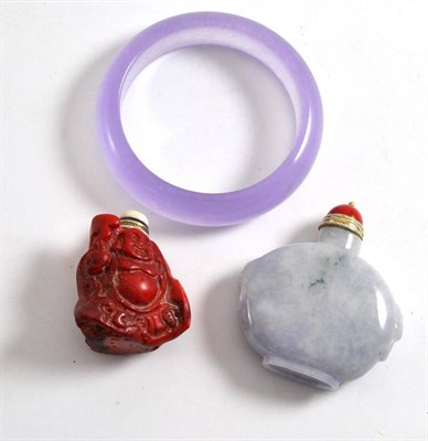 Lot 448 - A Chinese amethyst coloured jade type bangle, a similar pale blue snuff bottle and a coral type...