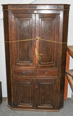 Lot 553 - A George III oak freestanding corner cupboard