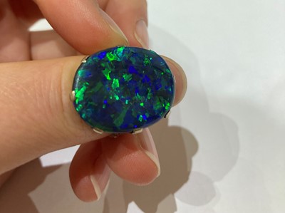 Lot 2290 - A Black Boulder Opal Ring, the oval cabochon...