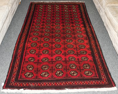 Lot 1125 - A Balouch rug, the crimson filed with rose of...