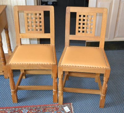 Lot 946 - A Pair of Robert  "Mouseman " Thompson Oak Lattice Back Dining Chairs, with cow hide...