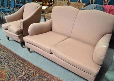 Lot 706 - A pink upholstered two seater settee on turned legs with brass castors and a similarly...