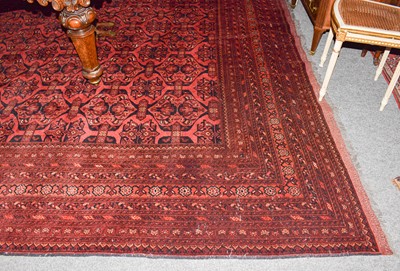 Lot 1000 - A large Afghan Turkmen carpet with a claret...