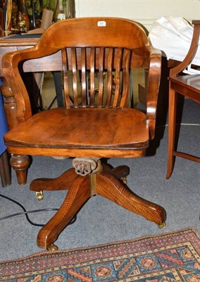 Lot 767 - A wooden swivel chair with brass casters