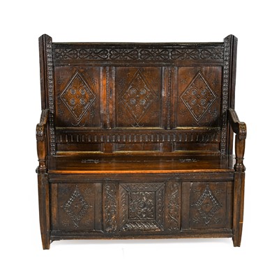 Lot 1379 - An Oak Box Settle, the carved top rail between...