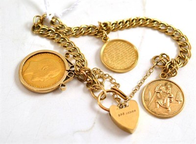 Lot 212 - A double curb link bracelet hung with two charms and a 1910 half sovereign