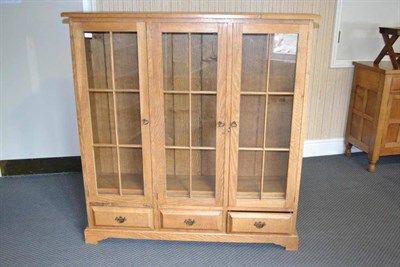 Lot 990 - A Modern Oak Glazed Bookcase, the rectangular top above three doors enclosing three adjustable...