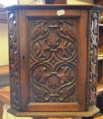 Lot 996 - An Arts & Crafts Carved Oak Hanging Corner Cupboard, with carved and tooled floral decoration...