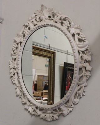 Lot 1420 - A white painted vine carved oval wall mirror...