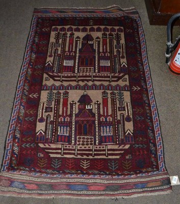 Lot 422 - An Afghan Balouch prayer rug, the field depicting mosques, enclosed by stylised plant borders