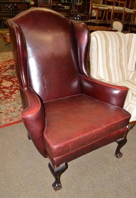 Lot 485 - Deep red upholstered wing back armchair