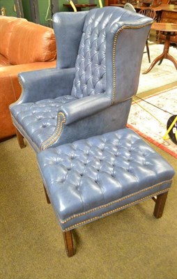 Lot 503 - A leather button back armchair and matching foot stool