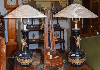 Lot 1297 - A pair of toleware table lamps in the form of...