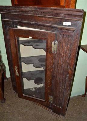 Lot 543 - An 18th century oak hanging corner cupboard with fluted stiles