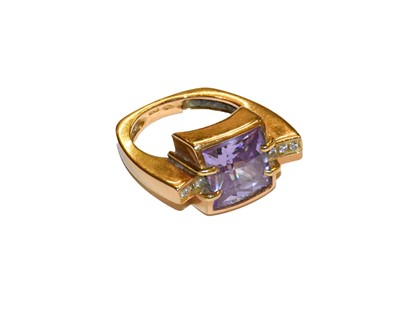 Lot 276 - A diamond and purple stone ring, stamped '750',...