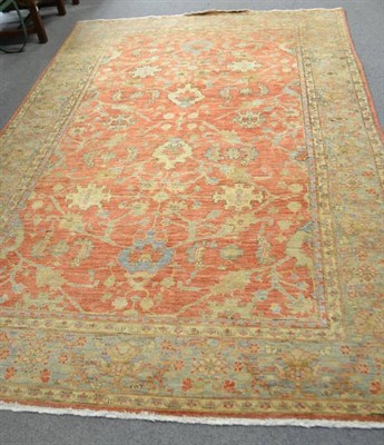 Lot 576 - An Afghan rug of Ziegler design, the rust field of scrolling vines framed by ice blue borders,...