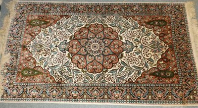 Lot 666 - Kashmir silk rug, North West India, the ivory field of scrolling vines around a salmon pink...