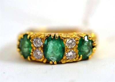 Lot 66 - An emerald and diamond ring in Victorian style, three graduated oval cut emeralds, spaced by...