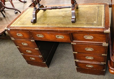 Lot 1344 - A campaign style twin pedestal desk, 122cm by...