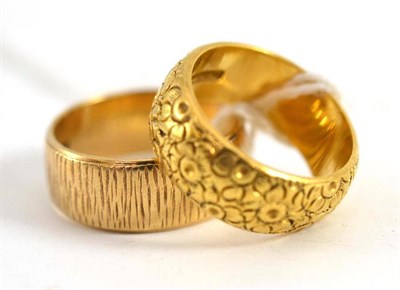 Lot 110 - An 18ct gold patterned band ring with floral decoration, finger size N and a 9ct gold patterned...