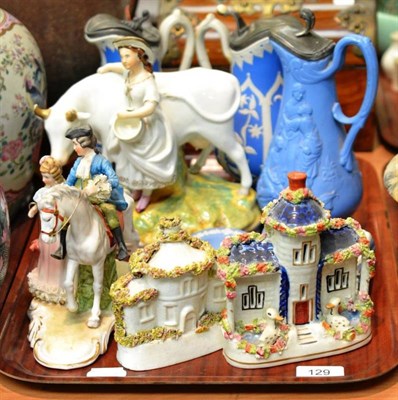 Lot 129 - Two pottery cottages, three relief decorated jugs, Staffordshire cow and milkmaid group, figure...
