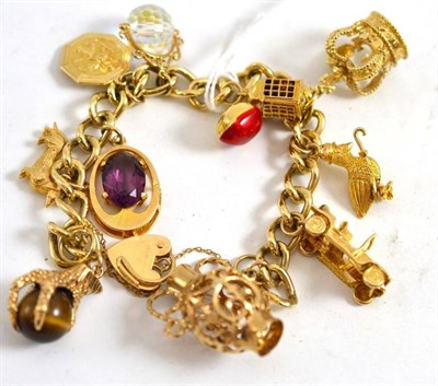 Lot 190 - A charm bracelet, padlock hallmarked 9ct gold, hung with eleven charms