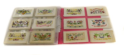 Lot 216 - A pink album containing 84 silk items, 81 of...