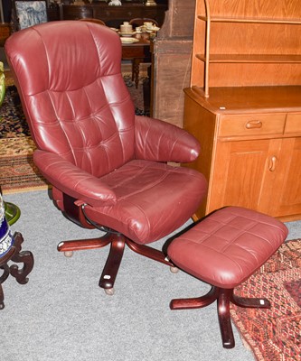 Lot 1280 - An burgundy leather swivel armchair and...