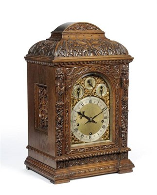 Lot 1053 - An Oak Carved Chiming Table Clock, circa 1890, leaf, scroll and mask carved decoration, pierced...