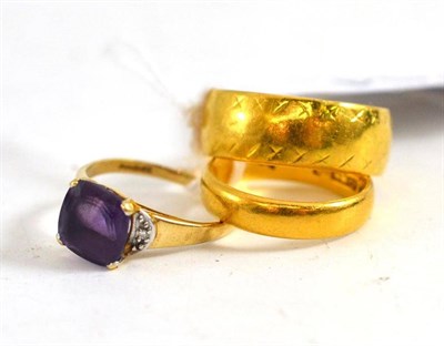 Lot 264 - Two 22ct gold band rings and an amethyst dress ring