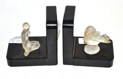 Lot 347 - Pair of bookends with moulded opaque glass figures of a bird and seated nude (2)