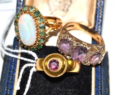 Lot 367 - An opal and emerald cluster ring, a garnet set ring and an amethyst ring