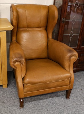 Lot 1111 - A tan leather wingback chair