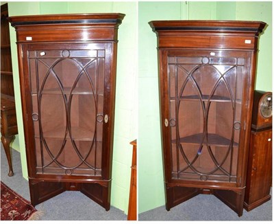 Lot 479 - A pair of mahogany standing glazed corner cabinets