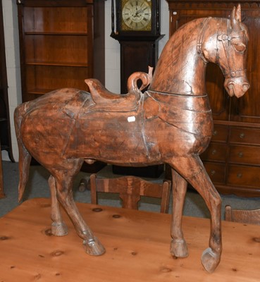 Lot 1085 - An early 20th century carved model of a horse...