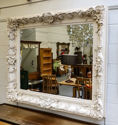 Lot 1097 - A large cream painted mirror, the bevelled...