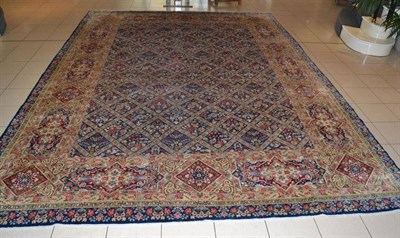 Lot 1088 - Kirman Carpet  South East Persia The indigo diamond lattice field of floral sprays enclosed by...