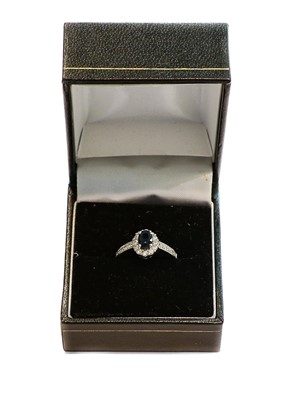 Lot 205 - A sapphire and diamond cluster ring, stamped...