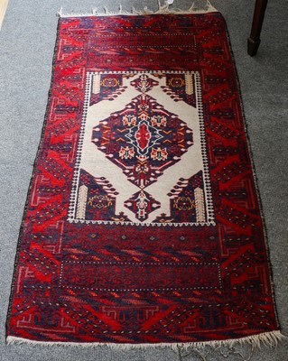 Lot 1111 - A Baluch rug, the ivory ground with central...