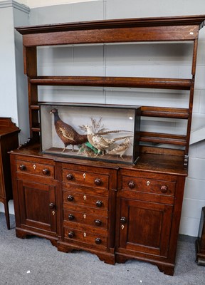 Lot 1257 - A George III oak breakfront dresser and rack,...