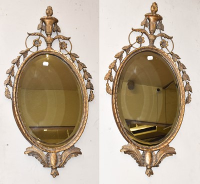 Lot 1186 - A pair of Adams style oval wall mirrors, the...