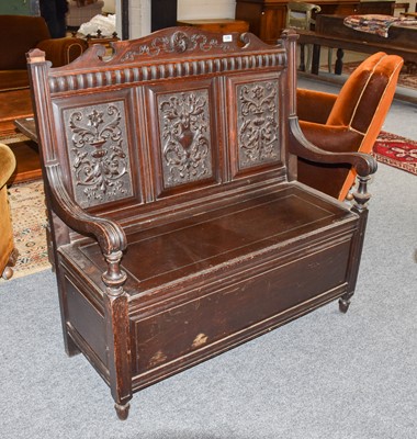 Lot 1280 - A late 19th century carved oak box settle,...