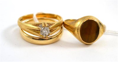 Lot 70 - A 9ct gold diamond ring, a 9ct gold tiger's eye ring and a 9ct gold band ring (3)