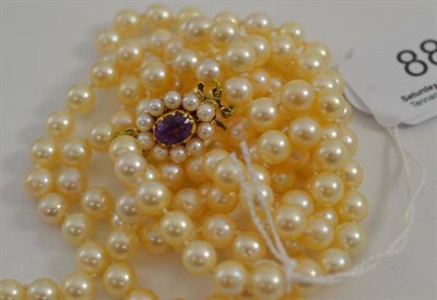 Lot 88 - Two row uniform cultured pearl necklace and amethyst snap